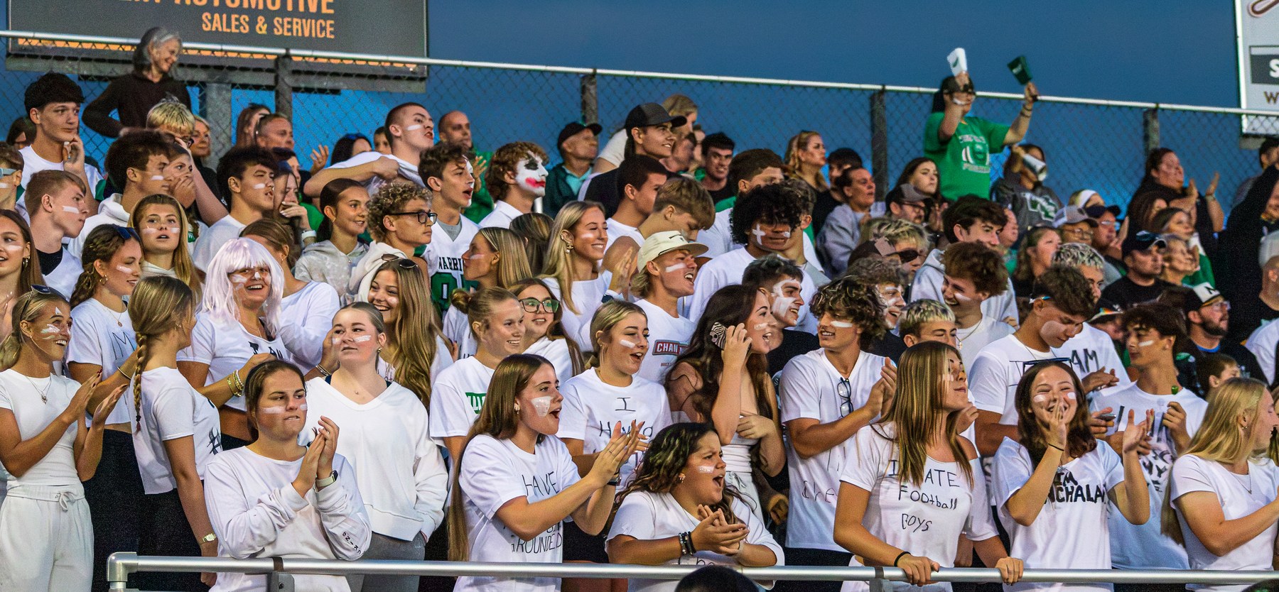 Fans cheering together in the stands during a football game, photographed by Wilcox Sports Media.